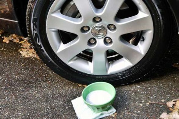 Un bol de nettoyant pour voiture bricolage fait maison devant un pneu