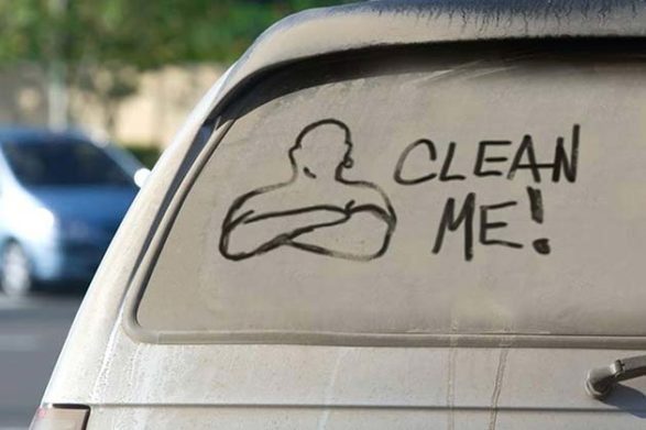 Une image de mr clean dessiné dans la saleté sur une vitre de voiture