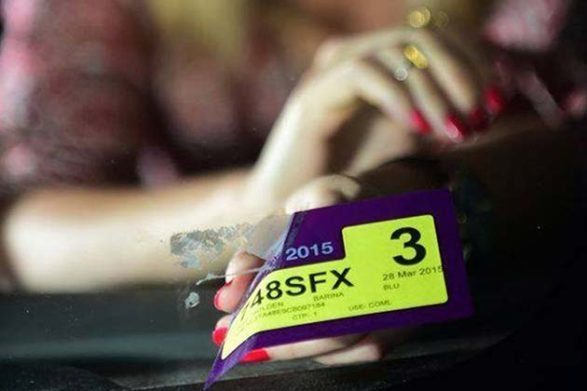 quelqu'un qui retire un autocollant d'une vitre de voiture