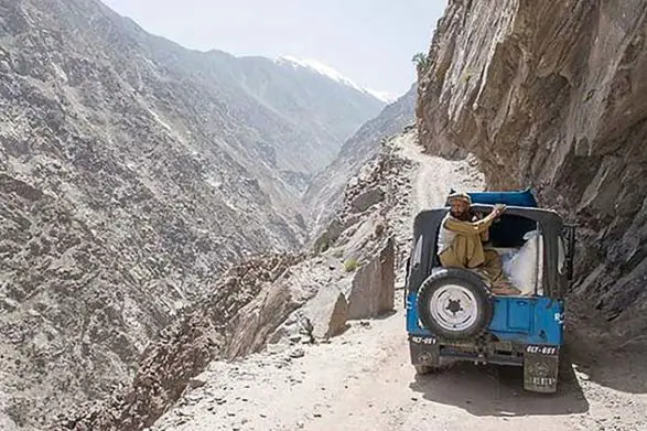 An SUV attempts to make its way along the narrow gravel road of the Nanga Parbat Pass in Pakistan