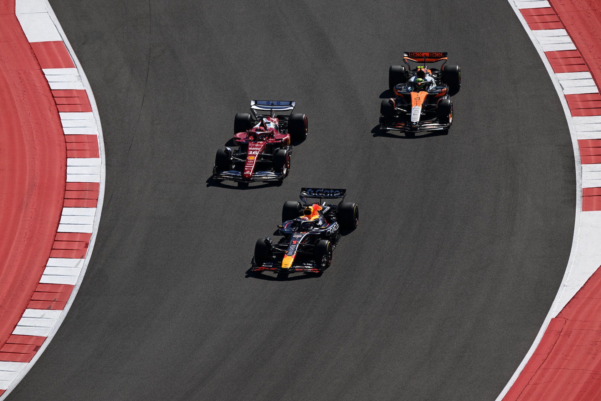 AUSTIN, TEXAS - OCTOBER 19: Max Verstappen of the Netherlands driving the (1) Oracle Red Bull Racing RB21 leads Charles Leclerc of Monaco driving the (16) Scuderia Ferrari SF-25 and Lando Norris of Great Britain driving the (4) McLaren MCL39 Mercedes atr the start during the F1 Grand Prix of United States at Circuit of The Americas on October 19, 2025 in Austin, Texas. (Photo by Clive Mason/Getty Images)